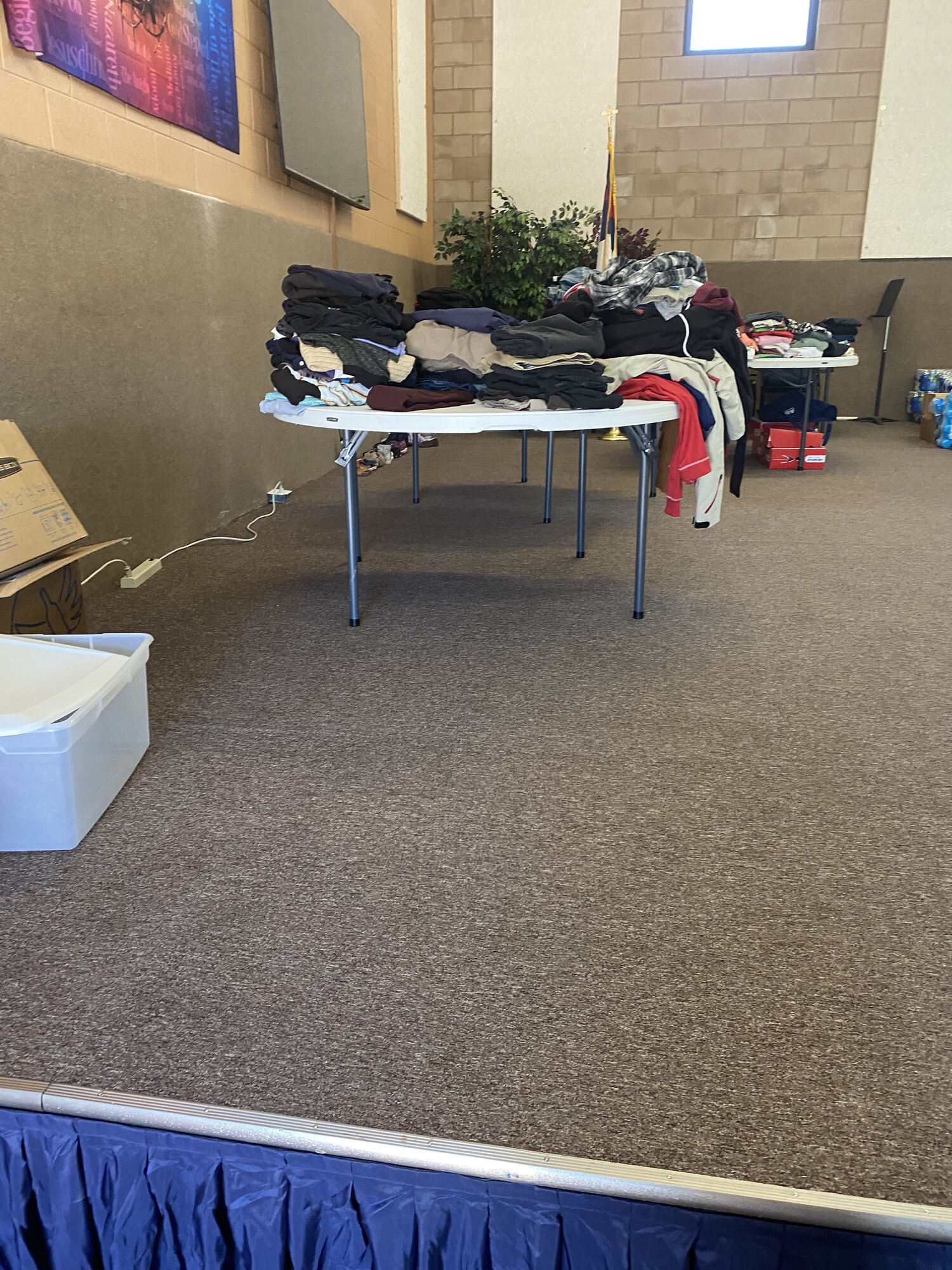 Donated clothing sorted and folded on tables for families displaced by the fire