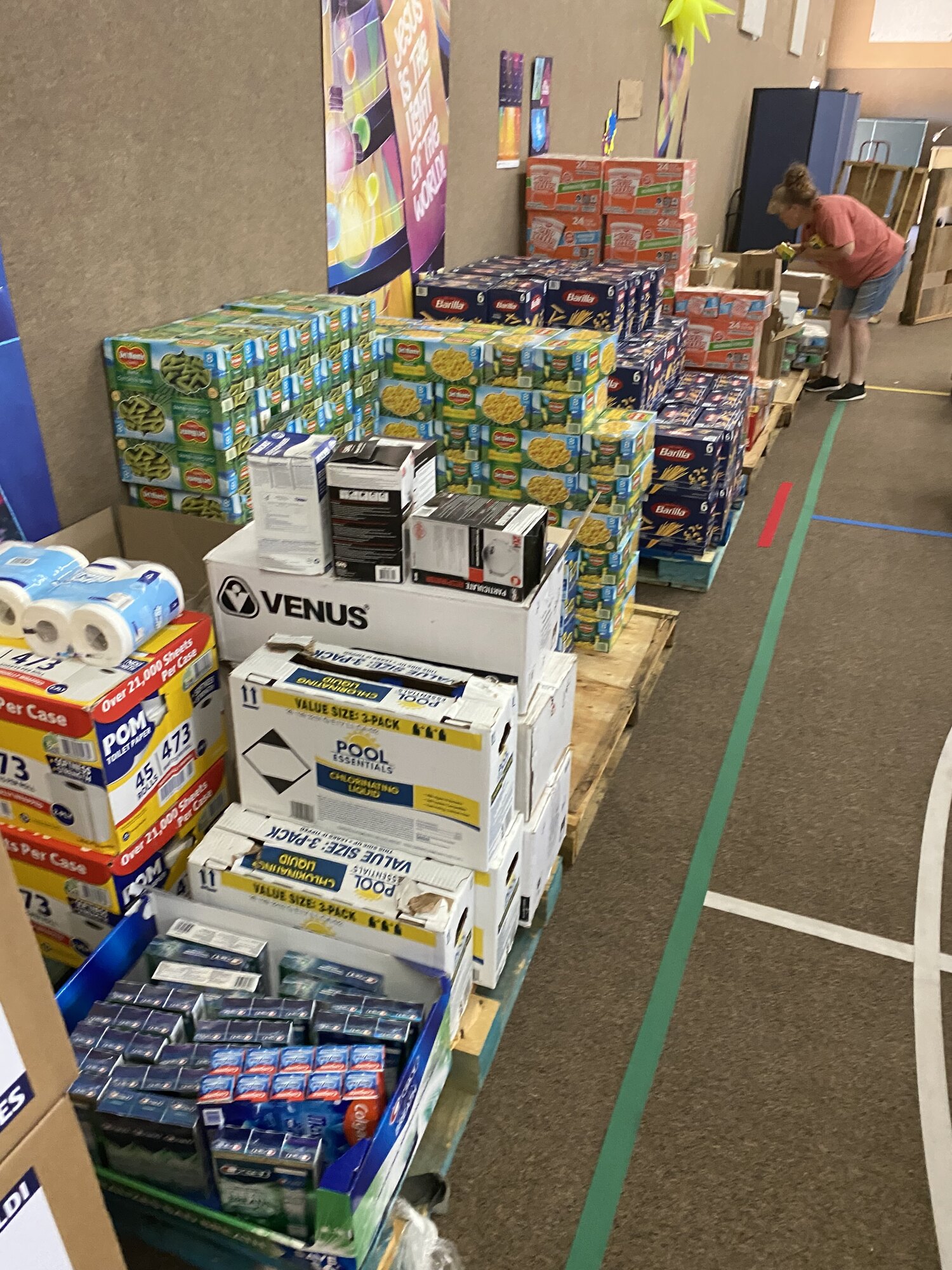 A volunteer sorting boxes of donated food and household supplies