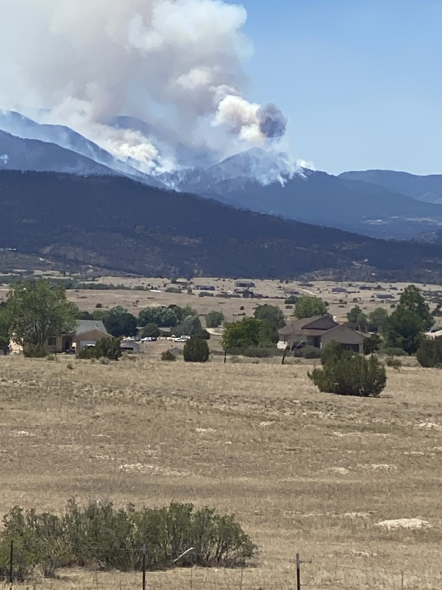 Smoke from the Aspen Acres Fire rising over the mountains above the valley