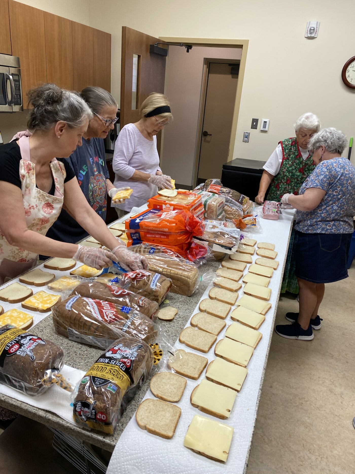 Heather Gardens senior volunteers assembling sandwiches at a long table for the Colorado Aspen fire relief drive