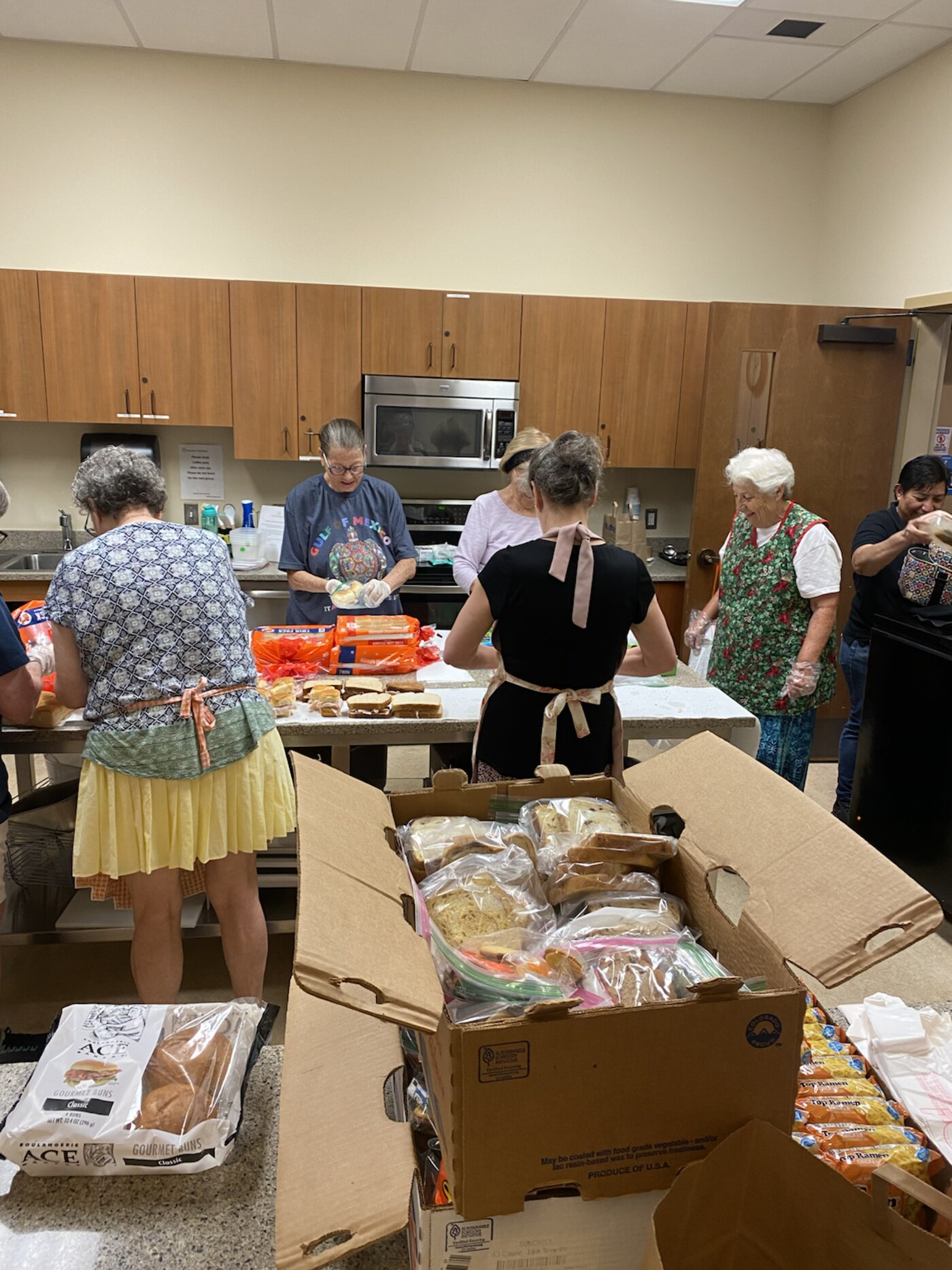 Senior volunteers packing food boxes in the Heather Gardens kitchen