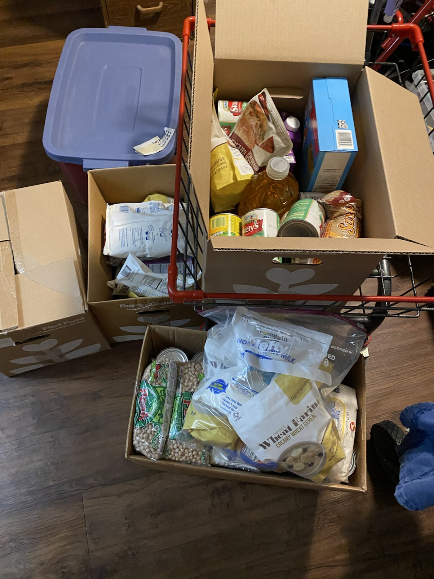 Cardboard boxes packed with donated bread, canned goods, and staples
