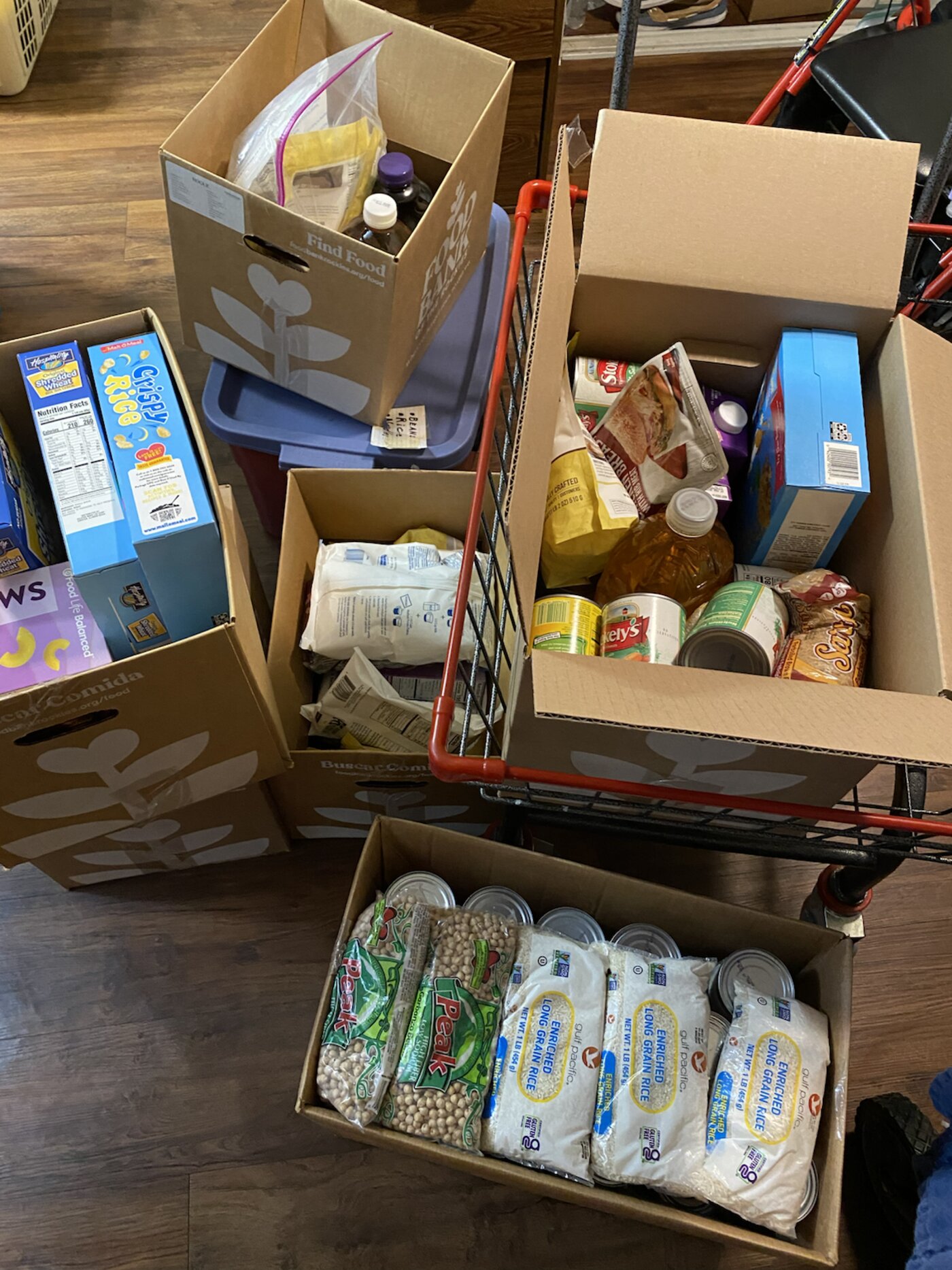 Care package boxes filled with donated groceries in a shopping cart