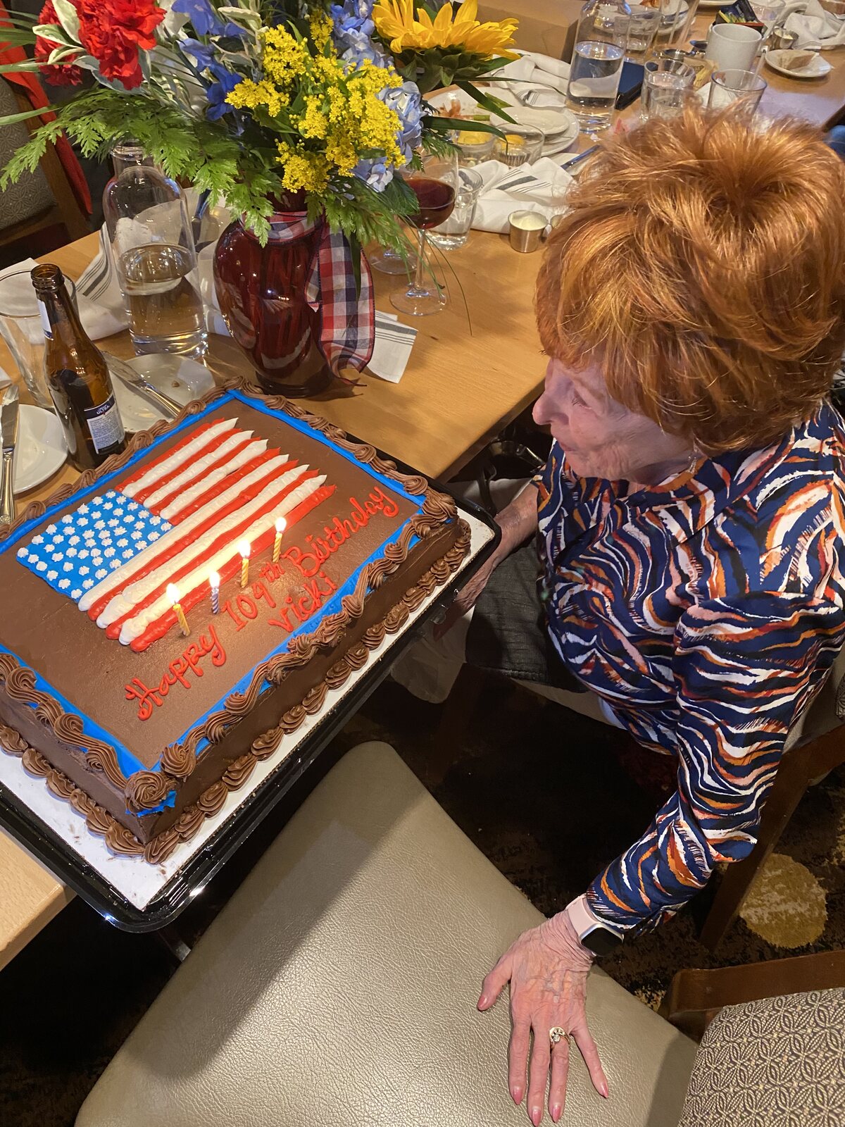 Vicki blowing out the candles on an American flag birthday cake