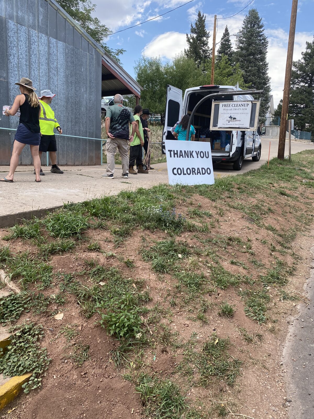 Residents lined up outside the Beulah community donation center beside a Thank You Colorado sign